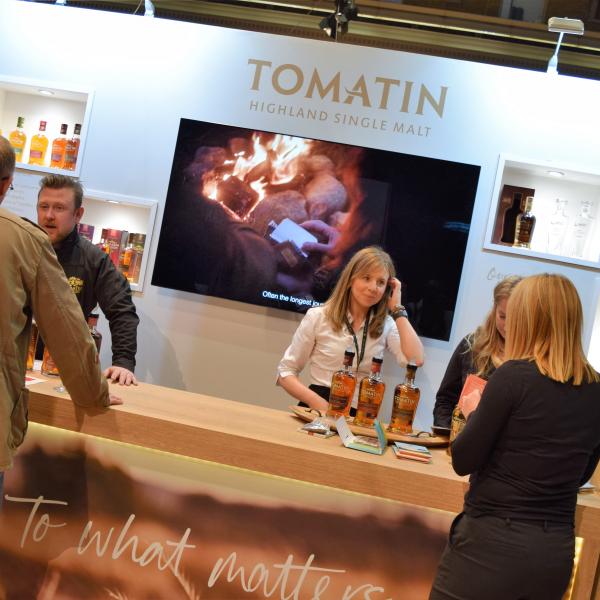 Exhibition stand for Tomatin showing people smiling