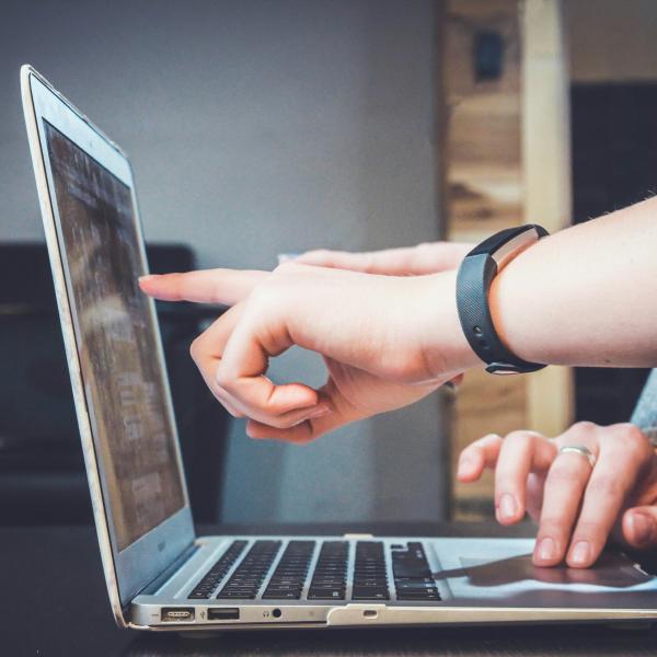 People pointing to a laptop screen