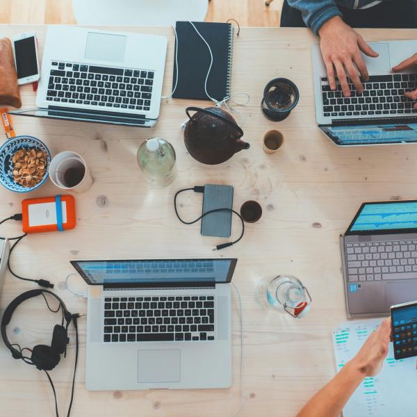 Several laptops and screens on a table